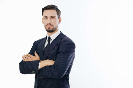 Studio portrait of serious young handsome confident entrepreneur folding arms and looking at cameraの写真素材
