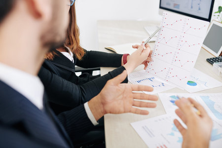 Business colleagues discussing growing line chart at meeting when working on investment research...