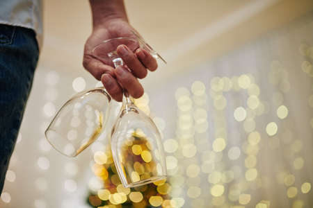 Close-up image of young man holding wine glasses prepared for New Year celebrationの写真素材