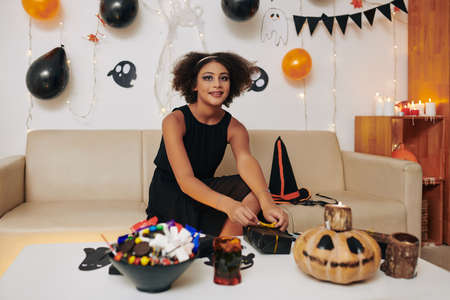 Smiling teenage girl Girl in Halloween witch costume at Halloween party at homeの写真素材