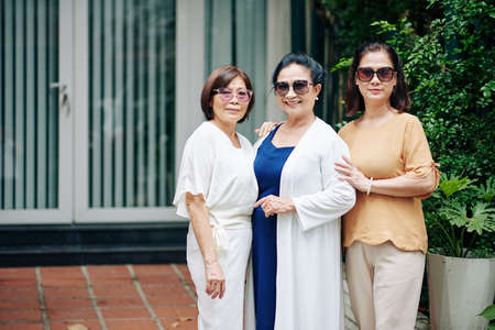 Group of happy senior female friends standing outdoors and smiling at cameraの写真素材