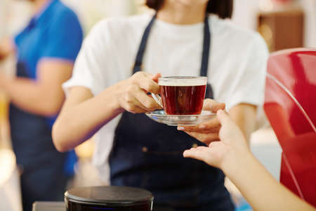 Waitress giving coffee to customerの写真素材