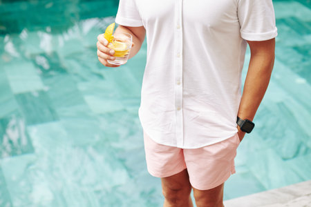 Man with gin near swimming pool