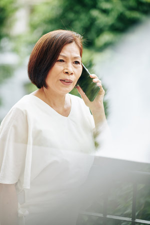 Elderly woman talking on phoneの写真素材