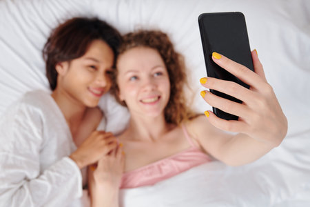 Lesbian couple lying in bedの写真素材