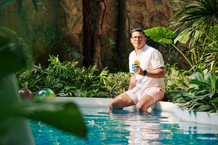 Fit man resting by poolの写真素材