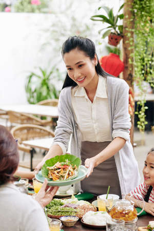 Housewife serving family dinnerの写真素材