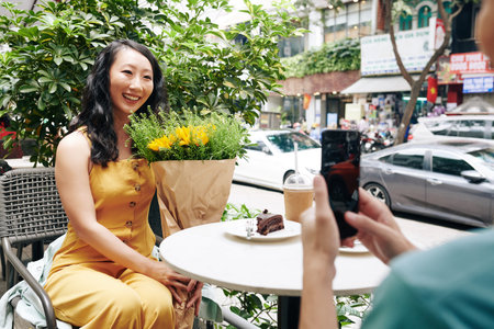 Woman photographing with bouquet