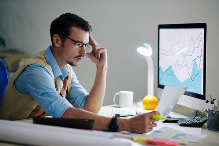Pensive analyst reading document