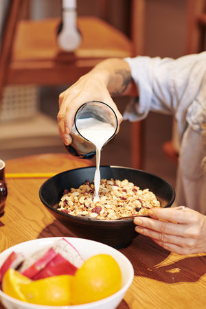 Pouring milk in bowl of muesli