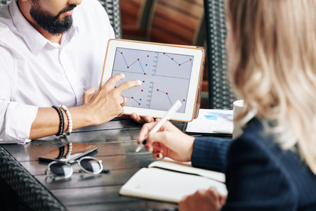Businessman showing line chart to colleague