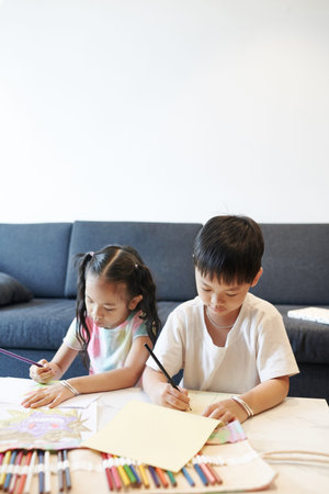 Siblings drawing with pencils