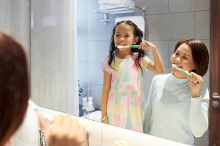 Mother and daughter brushing teethの写真素材