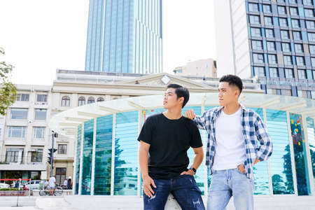 Asian young men in casual clothing standing in the city in summer dayの写真素材