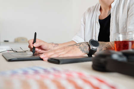 Hands of graphic designer using on graphic tablet when drawing logotype for clientの写真素材