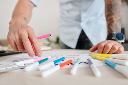 Close-up image of graphic designer using felt tip pens of various color when coloring logo mockupの写真素材