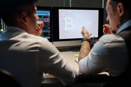 Doubtful financial brokers watching for bitcoin trading opportunitiesの写真素材