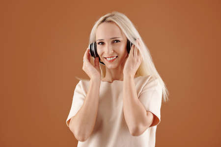 Portrait of pretty smiling young woman enjoying listening to music in headphonesの写真素材