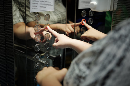 Woman pushing button with number five in hotel elevator, selective focus