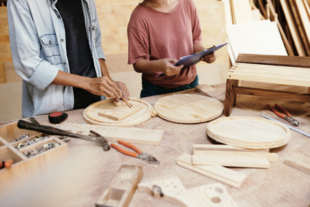 Team of carpenters making round wooden cutting boards for customer