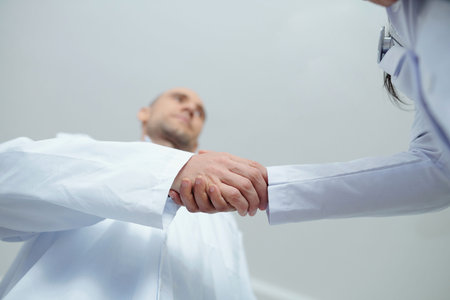 Medical workers shaking hands and greeting each other at the beginning of shift, view from below