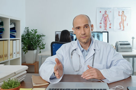 Portrait of physician in labcoat and earphones having online meeting or conference with colleagues