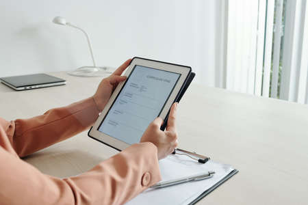 Hands of businesswoman entering personal information in curriculum vitae form on digital tabletの写真素材