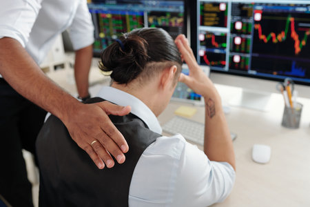 Trader patting sad desperate collegue on back reassuring him after he made bad investment