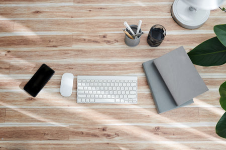 Computer keyboard, mouse, smartphone and books on office table, view from above