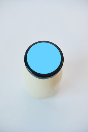 Bottle of fresh milk or yogurt on white kitchen table or counter