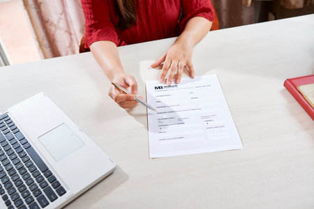 Hands of female real estate agercy manager asking customer to fill banking form with personal dataの写真素材