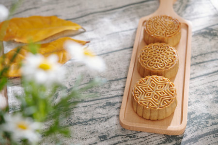 Wooden board with homemade mooncake prepared for mid autumn festival, selective focusの写真素材