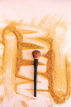 Makeup brush for application of golden glitter on face and body