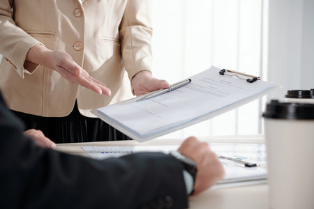 Assistant giving clipboard with document with order to her colleague to sign after meeting