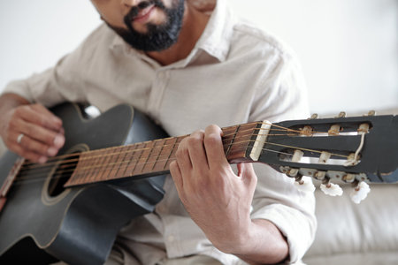 Cropped image of bearded man playing guitar and singing a songの写真素材