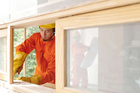 Serious construction worker installing new wiring in house and cutting wires with clippers toolの写真素材