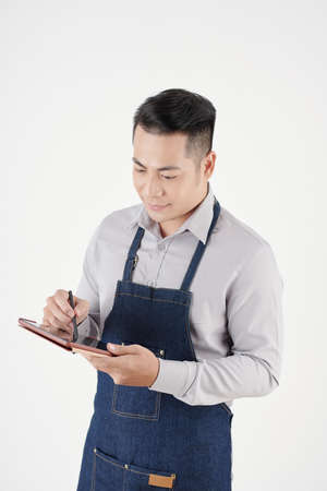 Studio portrait of coffeeshop owner using tablet computer when ordering supplies, coffee and milk delivery onlineの写真素材