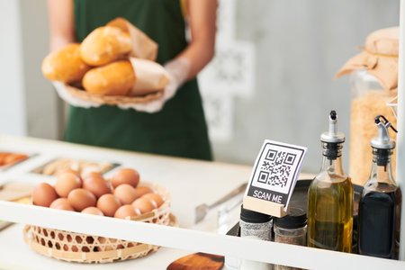 QR code for online payments on street food cart and vendor with plate of sandwiches in backgroundの写真素材
