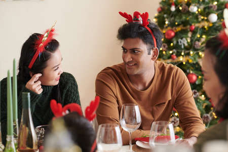 Young couple spending Chritmas dinner with family at homeの写真素材