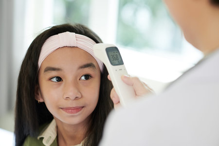 Face of girl having her body tempereature checked before getting vaccine against coronavirus