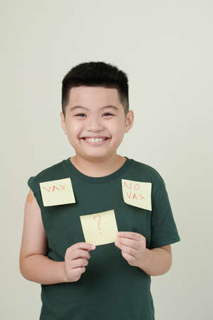 Smiling little boy doubting if he should get vaccinatedの写真素材