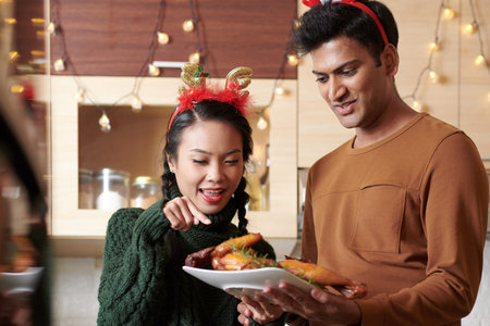 Couple looking at grilled chicken they cooked for Christmas dinner for the first time
