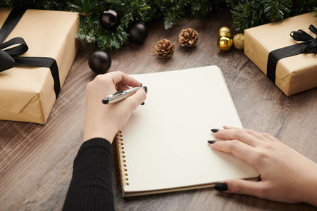 Hands of woman writing list of goals and plans for upcoming year