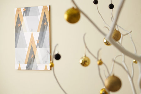 Picture with triangles representing Christmas trees hanging on wall in decorated room