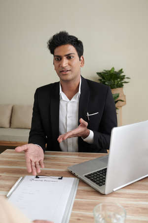 Property insurance agent explaining customer how to fill claim formの写真素材