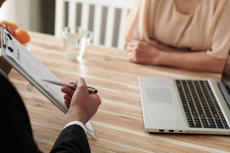 Cropped image of agent explaining female senior customer how to fill real estate insurance claim...