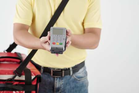 Cropped image of deliveryman with payment terminal and big insulated bag