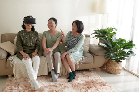 Group of senior friends trying to play virtual reality video game for the first timeの写真素材