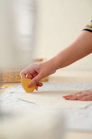Hands of seamstress using chalk when marking out sewing pattern on fabricの写真素材