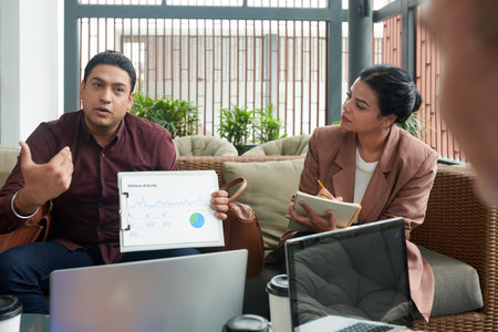 Head of marketing department showing report and explaining data with website visitors activityの写真素材